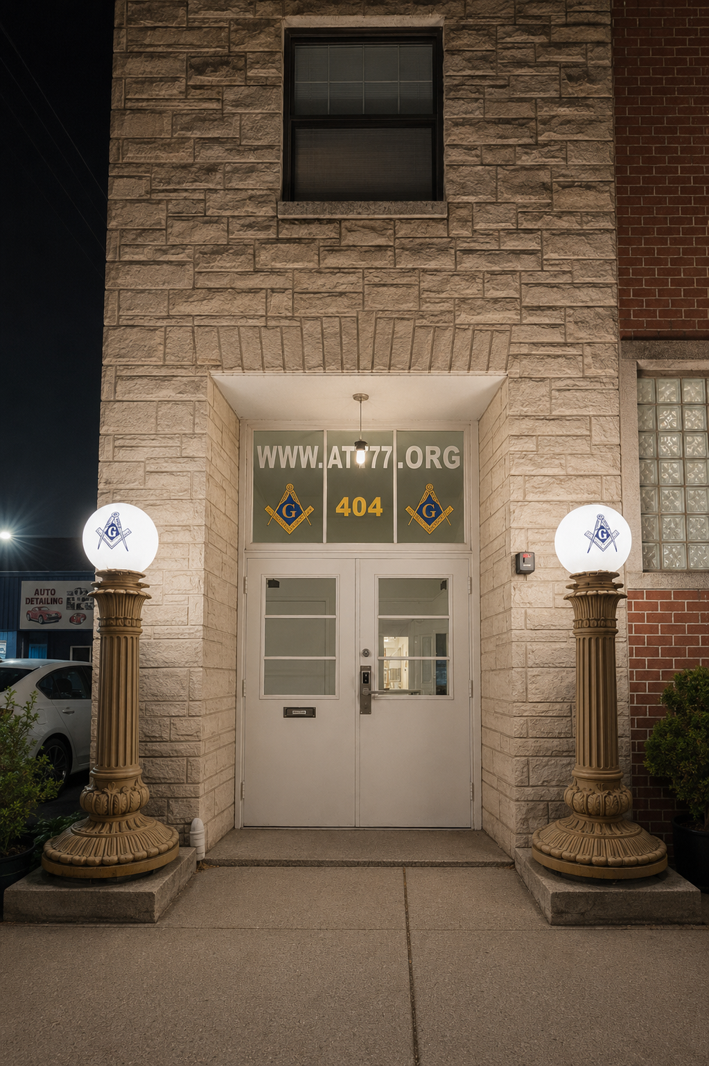 The entrance to Alpine Tilden Tenakill Lodge No. 77 at 404 Tenafly Road — the two Masonic pillars lit at night